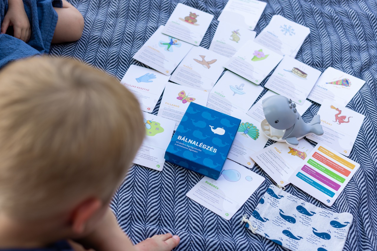 Bálnalégzés kártyák pokrócon, rajtuk egy Lego bálna, és két kisgyerek felülről